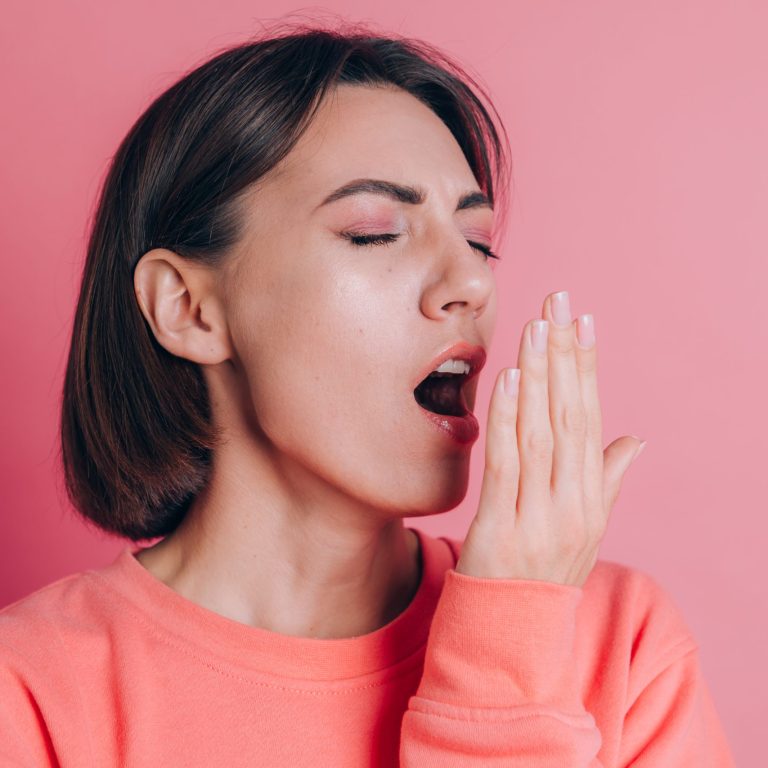 Woman wearing casual sweater on background bored yawning tired covering mouth with hand. Restless and sleepiness